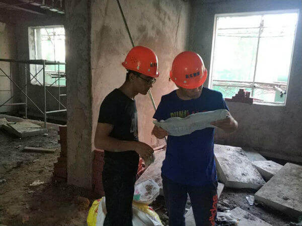 施工員正在查看圖紙商量如何綜合布線